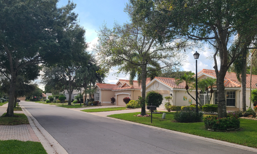 alt="Homes on a tree lined street in Valencia Lakes."